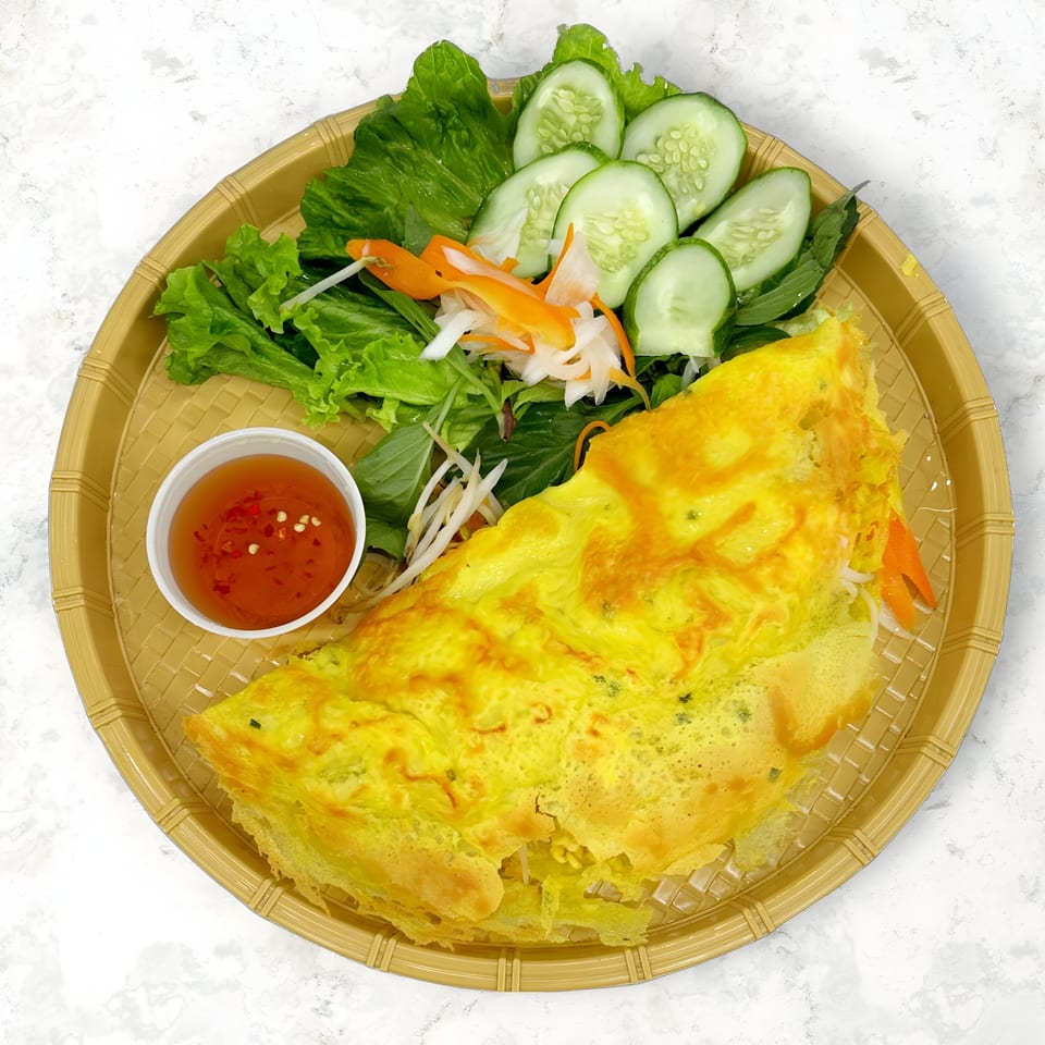 Mama Ha's Vietnamese Banh Xeo, a savory crepe, with lettuce, cucumbers, pickled vegetables, and dipping sauce.