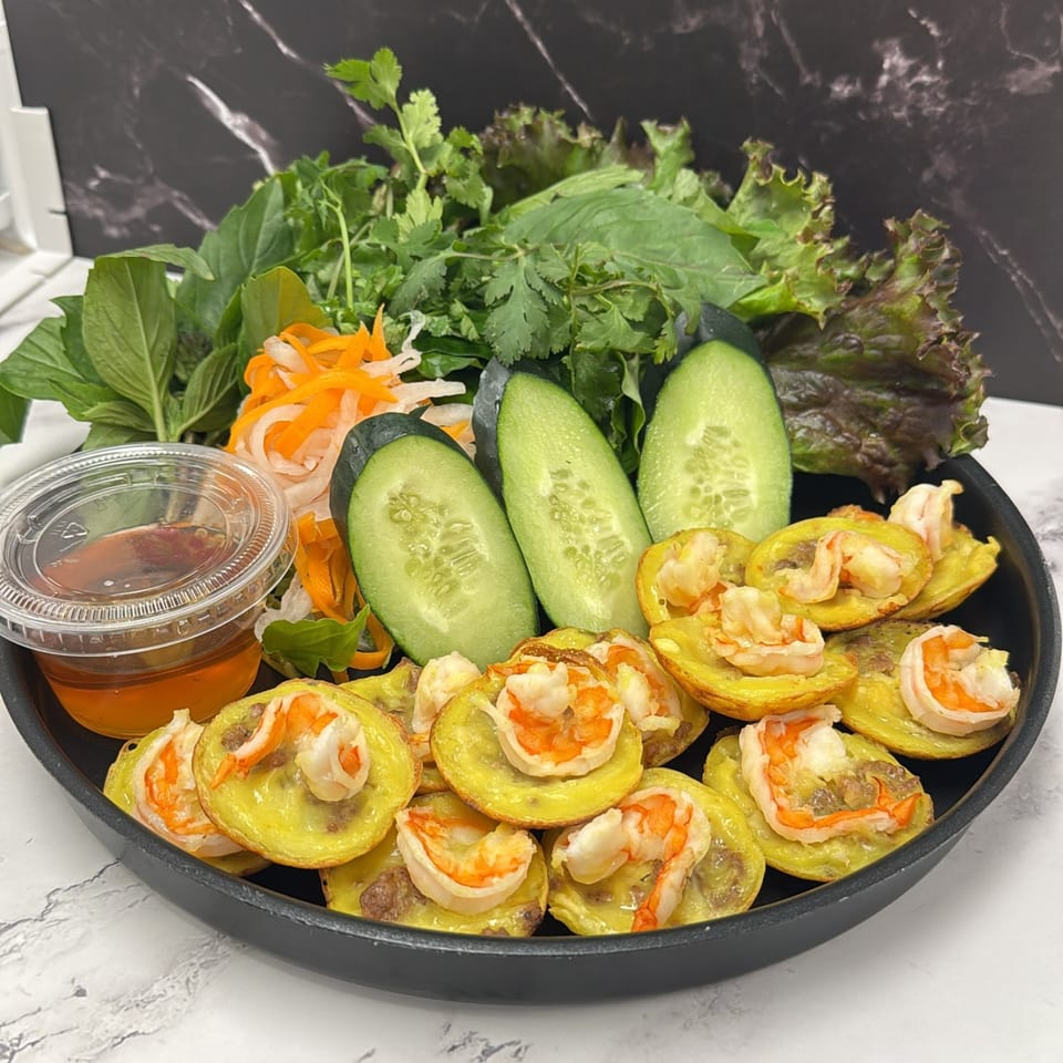 Mama Ha's Vietnamese Banh Khot, mini savory pancakes with shrimp, served with fresh herbs and dipping sauce.